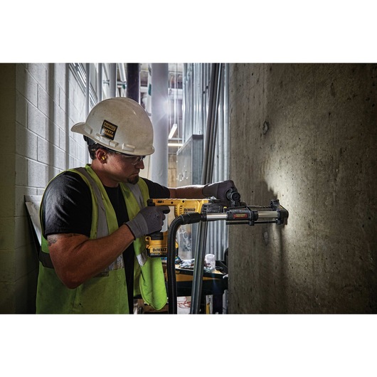 Rotary hammer with dust extractor telescope being used by person Rotary hammer with dust extractor telescope being used by person