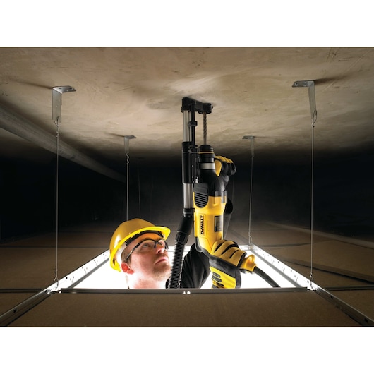 Rotary hammer with dust extractor telescope being used by person Rotary hammer with dust extractor telescope being used by person
