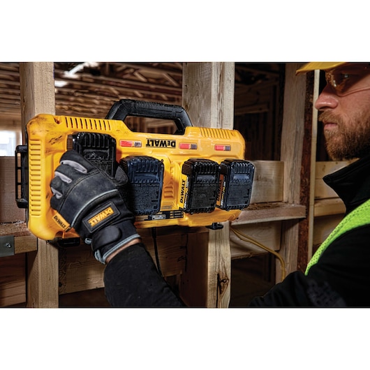 Battery being removed from Multiport Fast Charger by a construction worker Battery being removed from Multiport Fast Charger by a construction worker