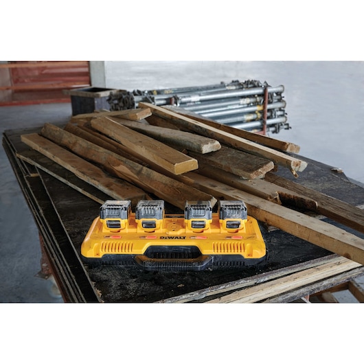 Multiport fast charger charging four batteries next to construction materials Multiport fast charger charging four batteries next to construction materials