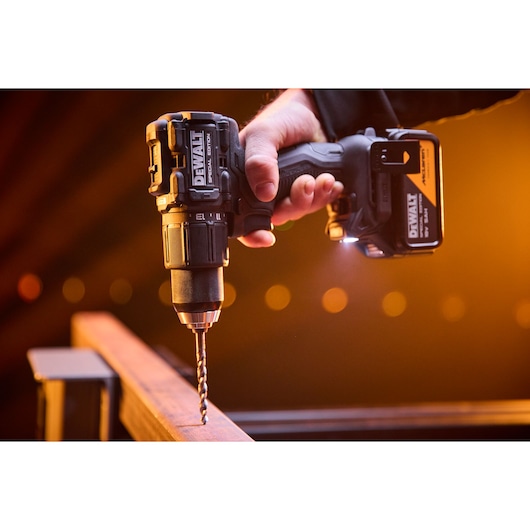 DEWALT x McLaren F1 Team 18V XR Special Edition Hammer Drill Driver with 5Ah battery drilling a metal bar