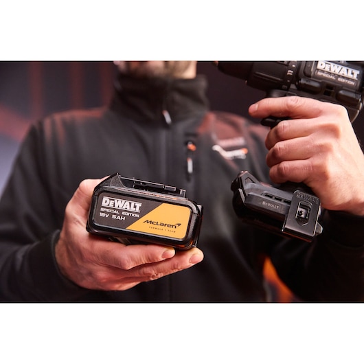 5Ah battery being connected to the DEWALT x McLaren F1 Team 18V XR Special Edition Hammer Drill Driver
