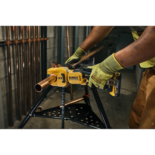 DEWALT 18V XR Brushless Copper Tubing Cutter being used to cut copper pipe on jobsite