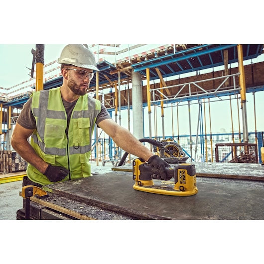 Construction worker prepares to lift a large sheet of timber using a Grabo 18V XR Suction Lifter