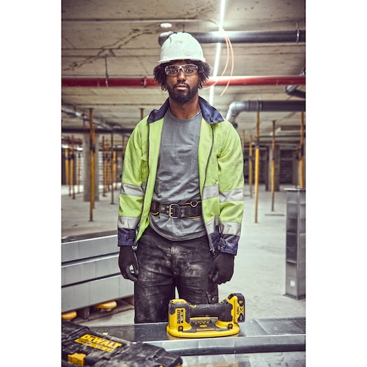 Construction worker standing behind the Grabo 18V XR Suction Lifter ready to lift the metal duct framework in factory