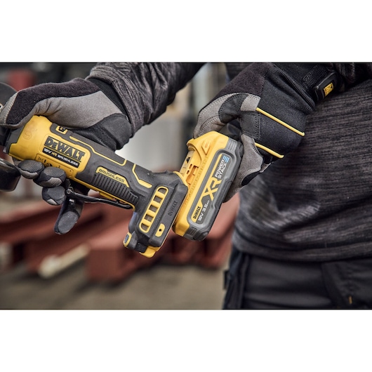 Powerstack battery being attached to the DEWALT 18V XR Compact 125mm Angle Grinder