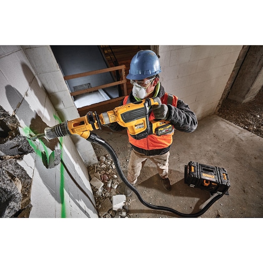 Brushless, cordless SDS MAX combination rotary hammer being used by a person Brushless, cordless SDS MAX combination rotary hammer being used by a person