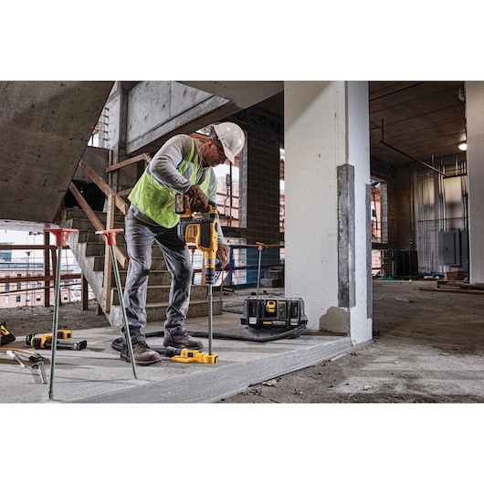 Brushless, cordless SDS MAX combination rotary hammer being used by a person Brushless, cordless SDS MAX combination rotary hammer being used by a person