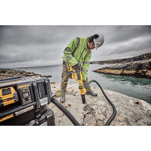 Brushless, cordless SDS MAX combination rotary hammer being used by a person Brushless, cordless SDS MAX combination rotary hammer being used by a person