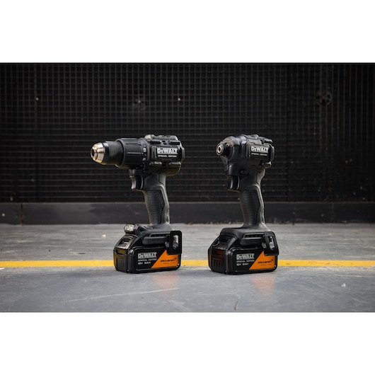 DEWALT x McLaren F1 Team 18V XR Special Edition Hammer Drill Driver and Compact Impact Driver with 5Ah batteries standing on a concrete floor