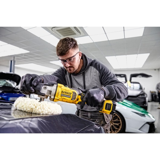 XR cordless variable speed rotary polisher being used by a worker to polish a car XR cordless variable speed rotary polisher being used by a worker to polish a car