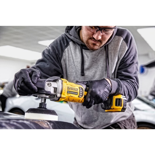 XR cordless variable speed rotary polisher being used by a person to polish a car XR cordless variable speed rotary polisher being used by a person to polish a car