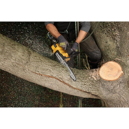 DEWALT 54V XR FLEXVOLT Compact Top Handle Chainsaw cutting a large tree branch