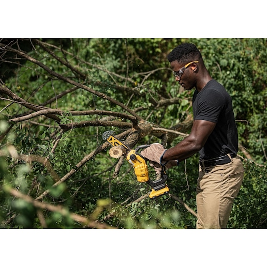 18V XR Brushless Chain Saw cutting a thick tree branch