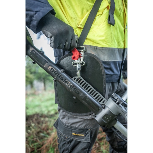 Close up of the deluxe harness worn by worker with the DEWALT 54V String Trimmer (D-Handle).