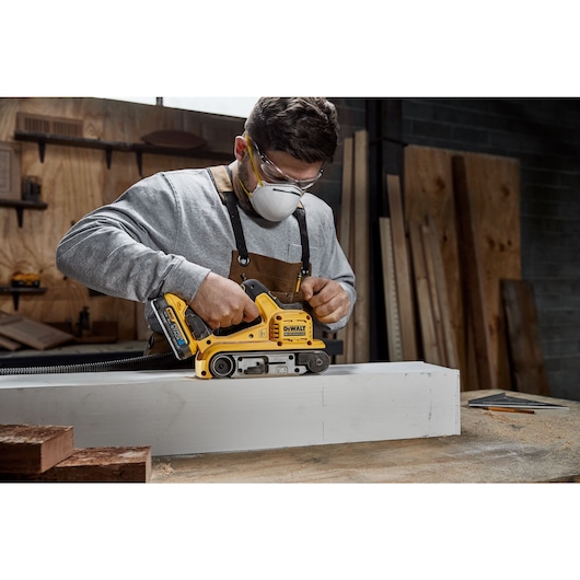 18V XR Brushless Belt Sander sanding a white wooden case