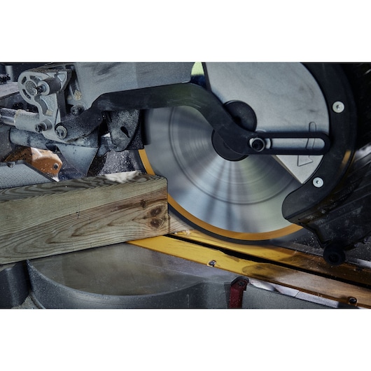 Close up of 305mm circular saw blade in a mitre saw fast cutting wood