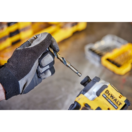 overhead shot of user in the process of putting a DEWALT Impact Screwdriver Bit into DEWALT drill