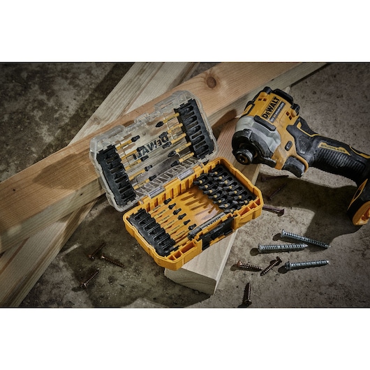 Flextorq set, screws and impact driver sitting on top of wood and concrete