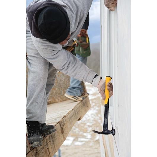 Mig weld checkered framing nailing hammer being used on a wall by a person.