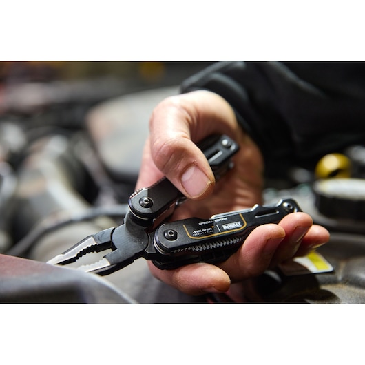 DEWALT multi-tool pliers held by a hand for precision mechanical work and versatile applications.