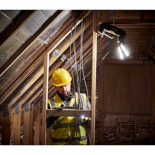 TOUGHSYSTEM 2.0 Cordless Adjustable Work Light hung on beam with intergrated hook on job site