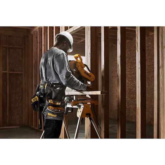 Workman operating a circular saw, wearing Dewalt Pro Tool Rig