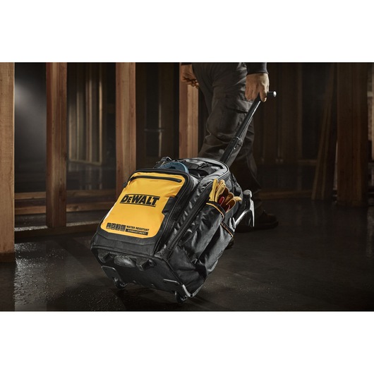Person rolling the Dewalt Pro Backpack on Wheels on a construction site Person rolling the Dewalt Pro Backpack on Wheels on a construction site