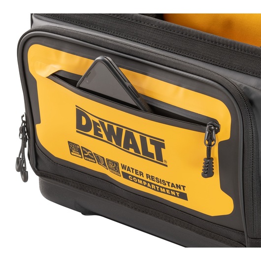 Close up of a mobile phone being slotted into the water resistant compartment on the Dewalt 20" Pro Tool Tote" Close up of a mobile phone being slotted into the water resistant compartment on the Dewalt 20" Pro Tool Tote"